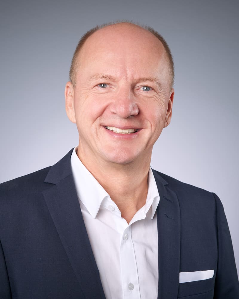 Porträt von Oliver Fischer, Versicherungsmakler in Memmingen, in dunklem Sakko und weißem Hemd
